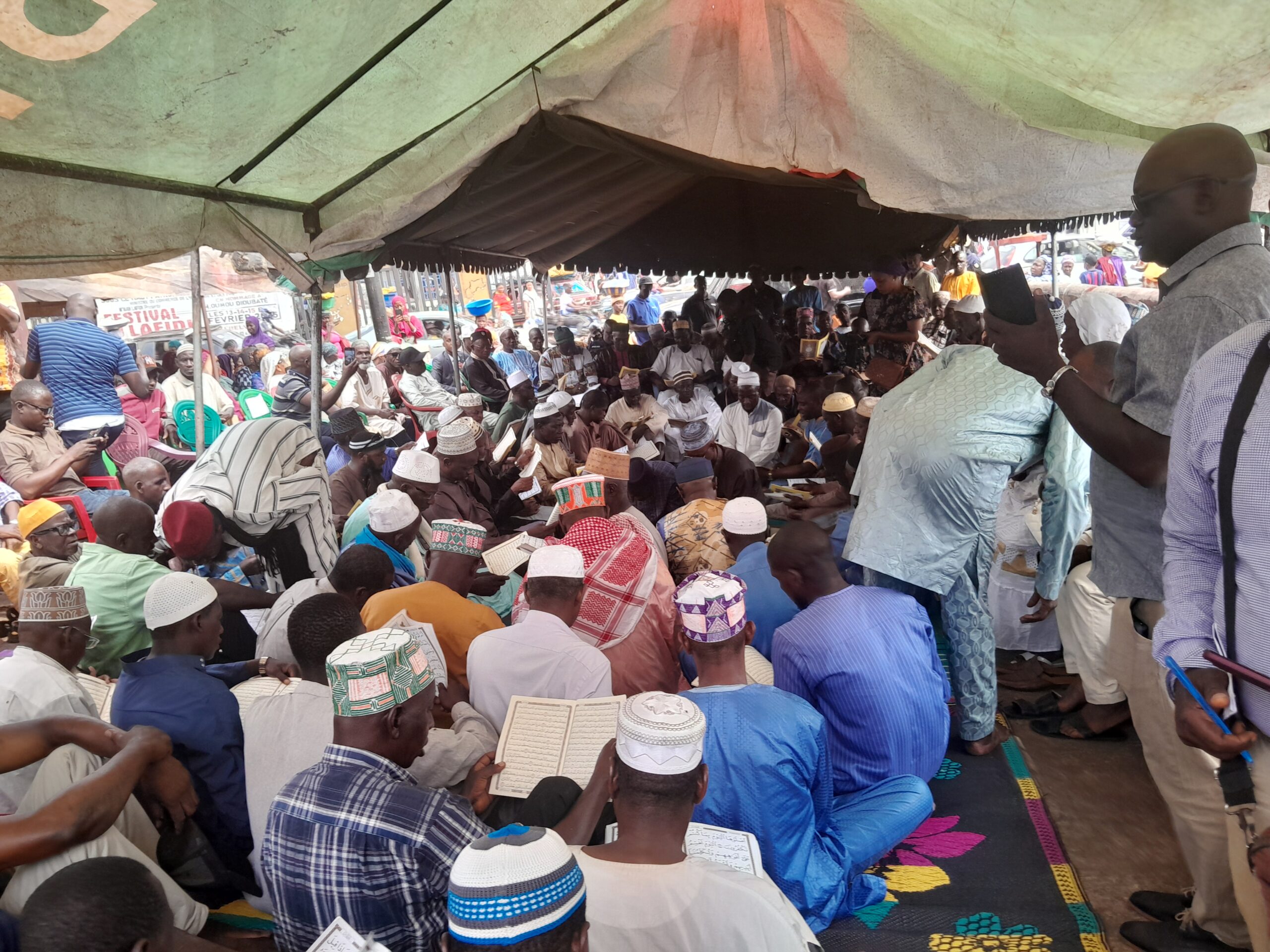 Des religieux réunis en train de lire le coran au grand marché d'Entag